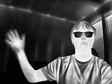 Two seconds of the goggles' thermal feed: a person waving at the camera in white-hot rendering
